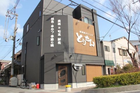 シックな黒の外壁と木の格子が印象的な居酒屋さんのサイン